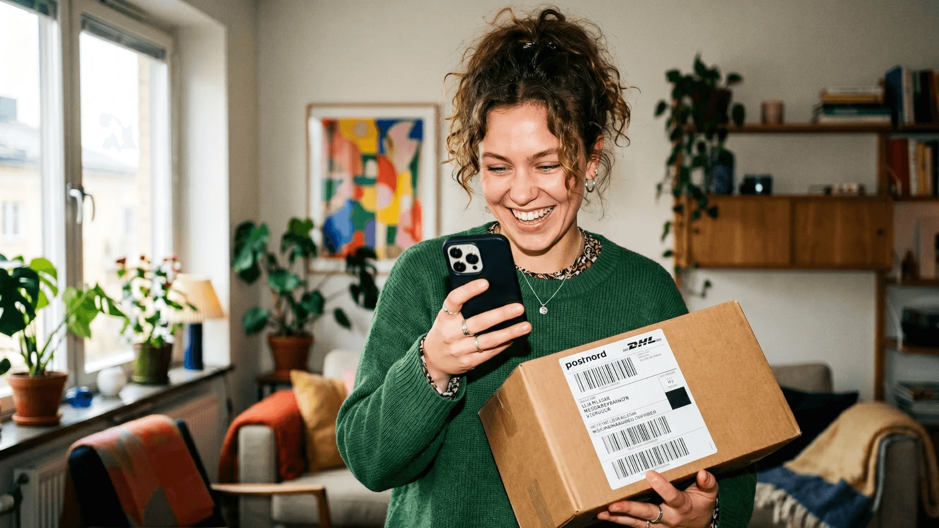 Person holding a shipping box and scanning with Plovie